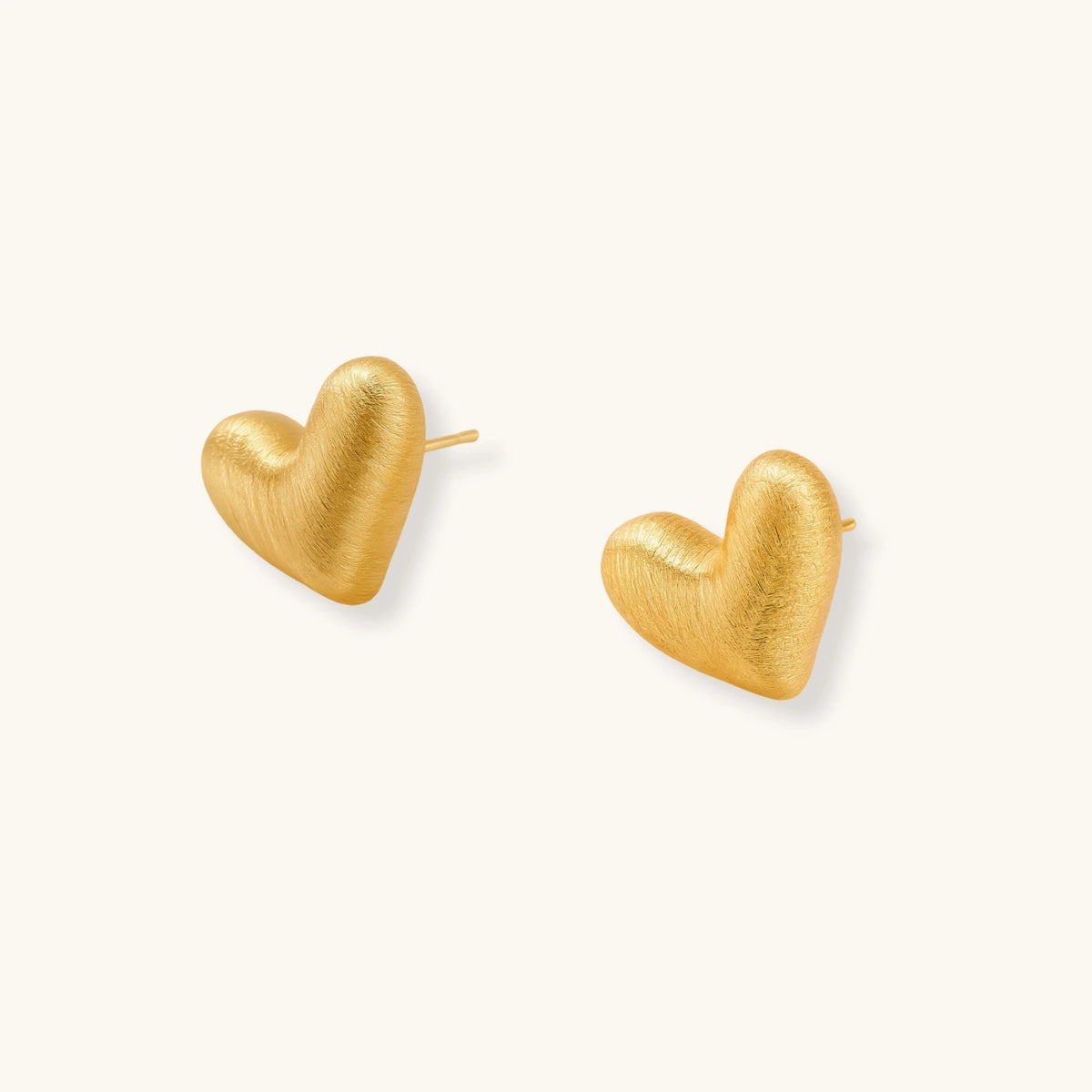 Pair of small heart-shaped stud earrings with brushed metallic finish, showing both silver and gold variants on neutral background.